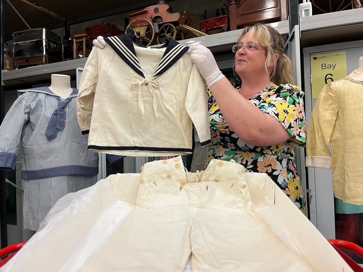 Sailor suits: Gemma Brown, site development officer at the Leeds Discovery Centre, with one of the eye-catching sailor suit style outfits in the Leeds collection.
The eye-catching naval attire includes a classic range of blue and white outfits, dresses and bellbottom trousers, looks which became hugely popular for children during the late 19th and early 20th centuries.
The suits are among an array of historic fashions which will be explored in an upcoming workshop at Leeds Discovery Centre looking back on centuries of fabulous clothes and costumes.