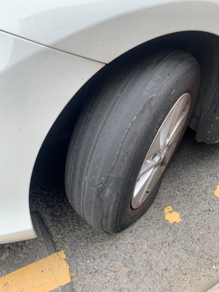 Unsafe tyre: The image shows a dangerous tyre due to lack of tread. You should check your tyre tread regularly, especially before long journeys. Tread depth is important for maintaining traction on wet roads and preventing hydroplaning. To check thread depth, insert a 20p coin into the tread grooves of your tyre. If you can't see the coin's outer rim, your tyre tread is above the legal limit. If you can see part of the rim, your tyre tread is likely below the legal limit and you should have it inspected by a mechanic.