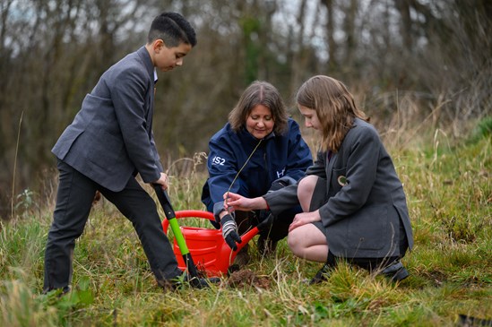 Pupils from High Meadow Community School planting an oak sapling with assistance from an HS2 representative, March 2022