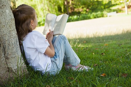 Girl sat under tree reading a book