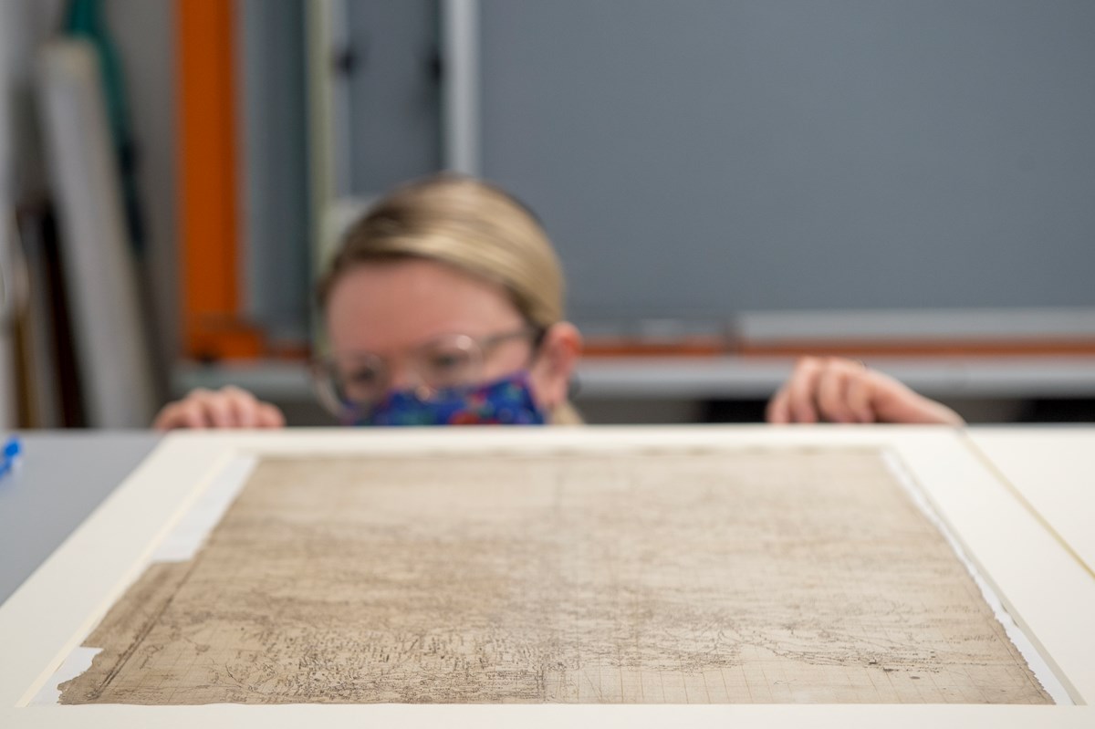 Library Conservator Lizzie Fuller inspects a Timothy Pont map (1596)  - detailing most of the drainage basin of the River Clyde. Credit: Neil Hanna