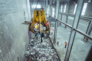 A grabber takes the waste and empties into a hopper