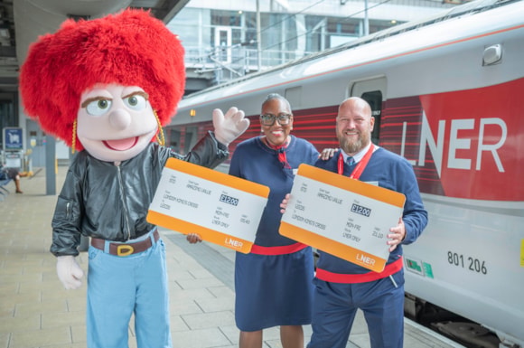 LNER colleagues in Leeds station with Eleanor to share £12 fare news with LNER Azuma train