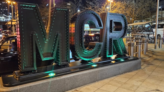 This is MCR: new sculpture unveiled to welcome and protect passengers: MCR sign at night