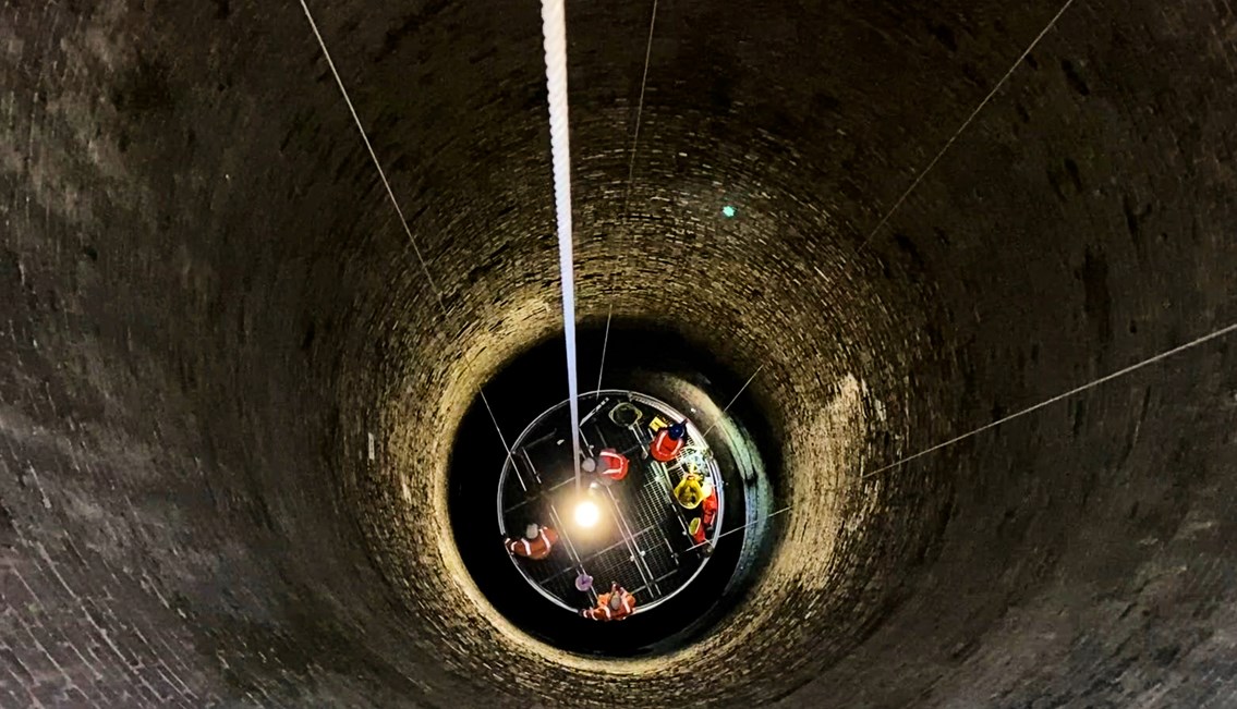 Cradle descending into the darkness of Cowburn Tunnel's 250m deep ventilation shaft
