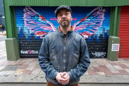 Artist Rogue One in front of the First Bus mural
