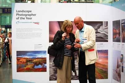 Landsacpe Photographer of the Year exhibition 2013: Charlie Waite gives advice to member of the publci at Manchester Station exhibition