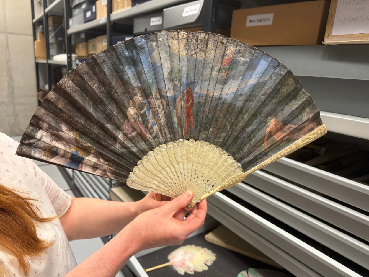 Antique fans: Curator Natalie Raw holds a stunning 350-year-old fan depicting a legendary scene from the Trojan War which is being conserved at Leeds Discovery Centre.
Crafted in around the 1680s, the beautiful folding hand fan, complete with sticks carved from antique ivory, captures The Judgement of Paris, a fateful mythical moment which saw the Trojan prince choose which of three ancient goddesses- Hera, Athena, or Aphrodite- was the most beautiful.
