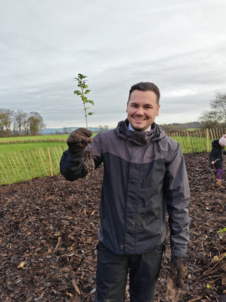 Councillor Joshua Roberts holding one of the saplings ready to plant