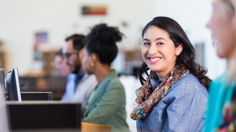 female smiling to camera in a group setting with pcs