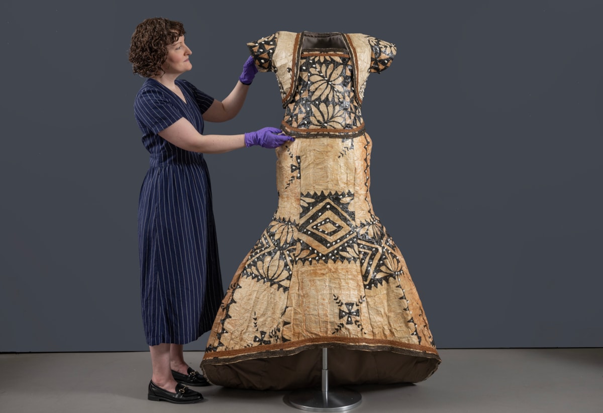 Curator Ali Clark prepares the barkcloth wedding dress for display. Photo © Neil Hanna (2)