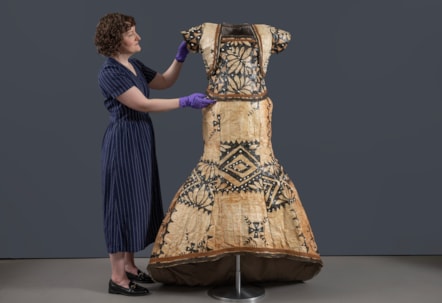 Curator Ali Clark prepares the barkcloth wedding dress for display. Photo © Neil Hanna (2)