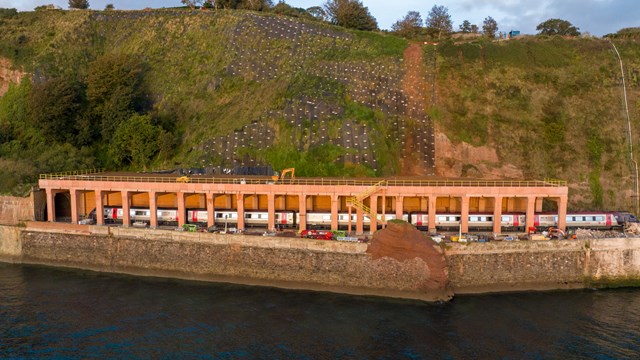 Network Rail looks to the next stages of south Devon railway resilience as rockfall shelter is completed: A CrossCountry train passes through the rockfall shelter,