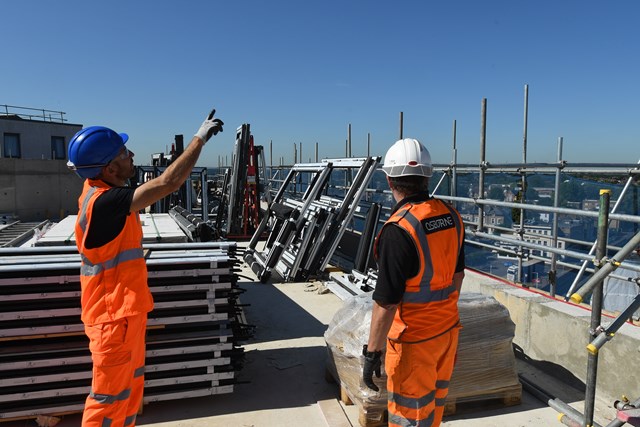 Network Rail to reduce its third party works fees: Engineers on rooftop worksite next to railway