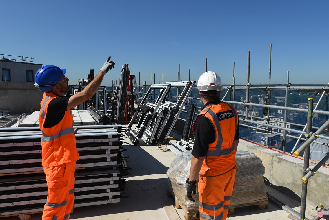 Engineers on rooftop worksite next to railway: Open for Business, OfB, Engineer, Asset Protection and Optimisation, ASPRO, partnership, partner, client, third party, outside party, railway, building, construction, generic, worker, worksite, work, team briefing