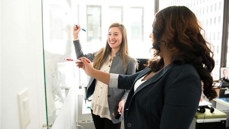 women writing on whiteboard