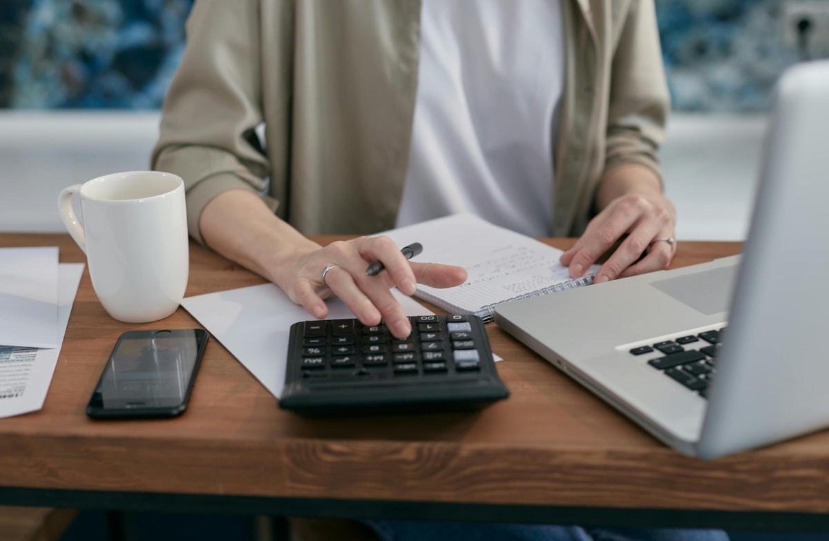Person with laptop, paperwork and calculator