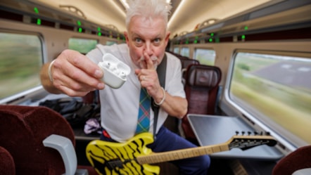 Robb Weir onboard LNER train with guitar calling for quiet