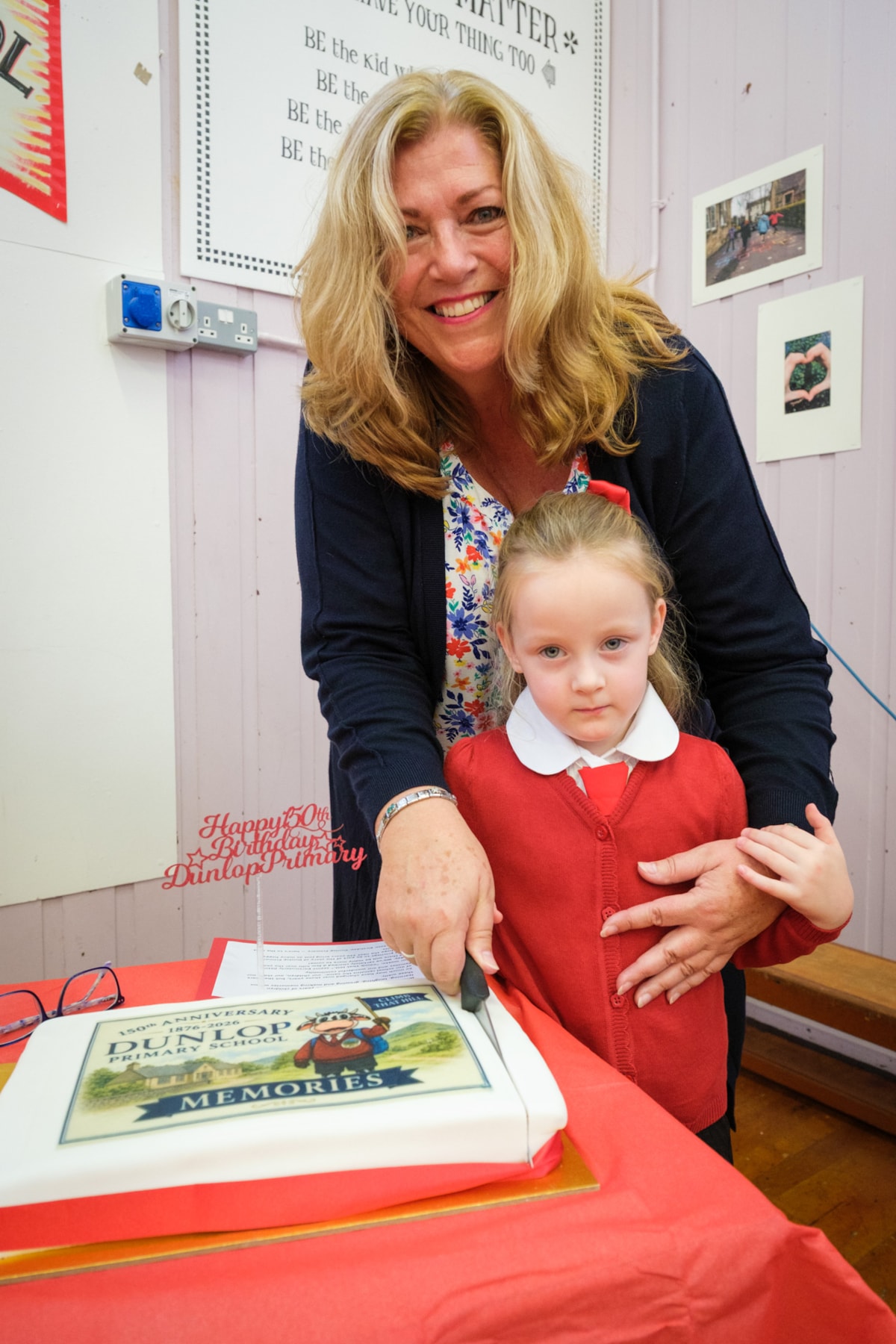 Miss McCrae with Eva cutting the celebratory cake