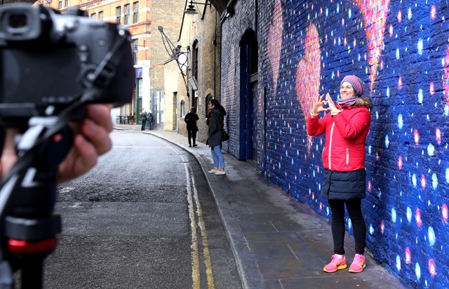 A passer by poses with Jimmy C's art in Southwark: A passer by poses with Jimmy C's art in Southwark