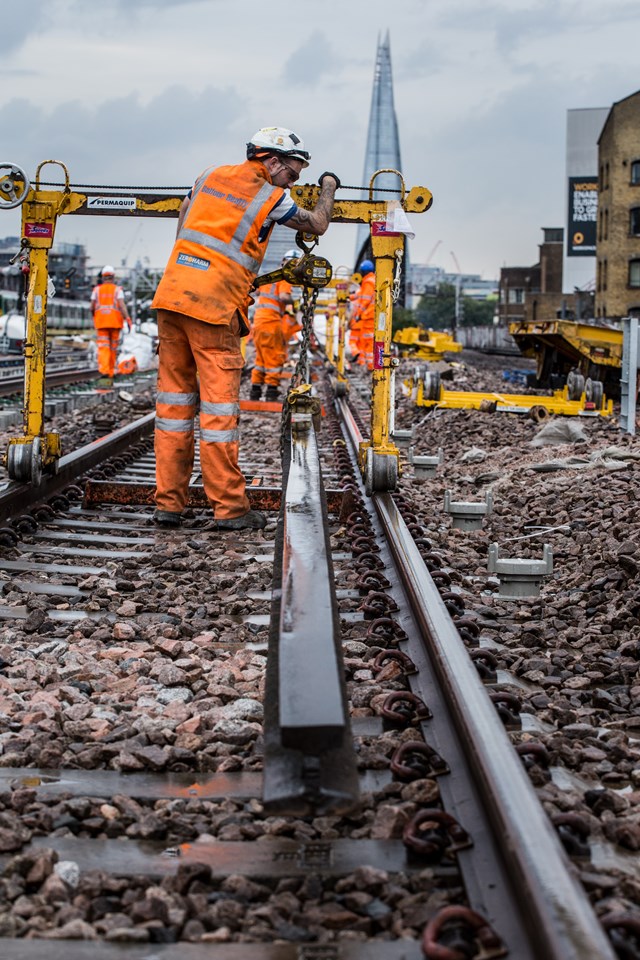 London Bridge August 2015: A rail worker delivers new conductor rail to site at London Bridge, using a piece of equipment called an 