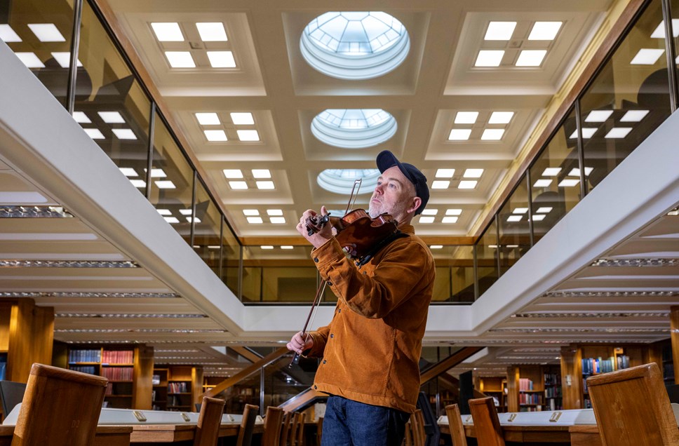 Fiddler Aidan O'Rourke in the General Collections Reading Room at the National Library of Scotland's George IV Bridge building. Credit: Neil Hanna