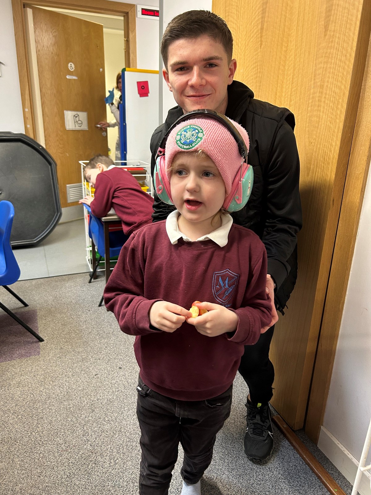 Buckie thistle midfielder Marcus Goodall with Harper Mayo from The Bothy at Millbank Primary in Buckie.