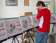 Party for the warren - plans: Person looking at several display boards showing proposed housing plans for the local area