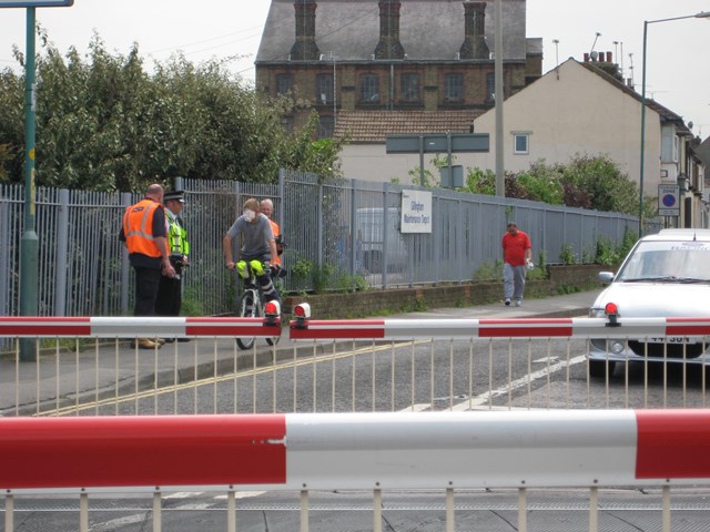 Gillingham Level Crossing Awareness Event 3: A police officer and railway employees speak with a cyclist about using level crossings safely