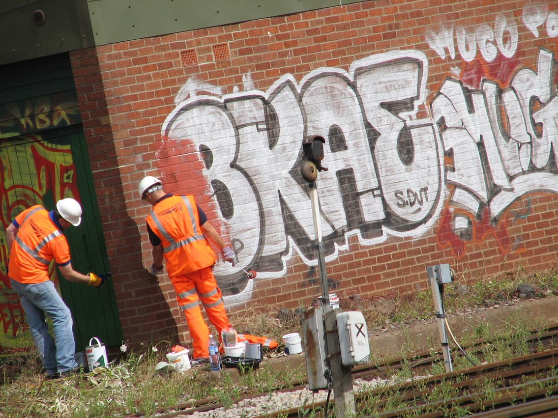Tackling graffiti - Bristol Temple Meads: Maintenance team tackle huge amount of graffiti on line side building as part of the one mile clean up either side of Bristol Temple Meads station, 31 July 2006