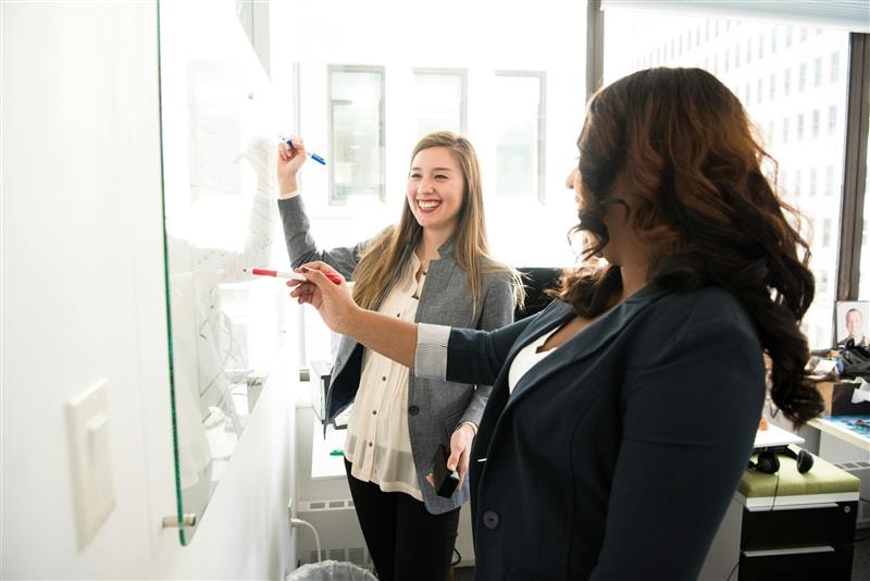 women writing on whiteboard