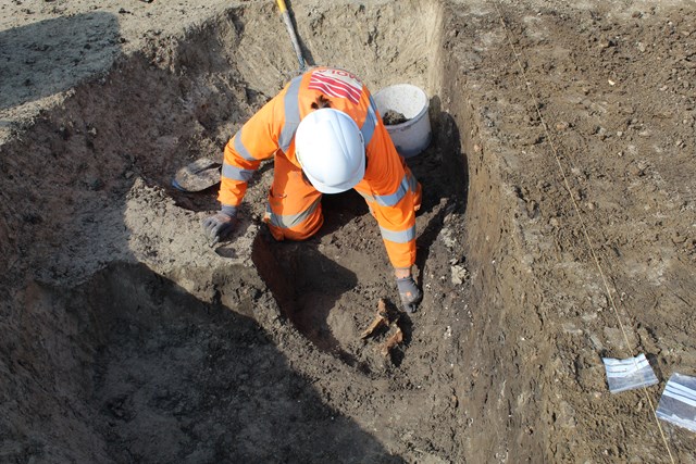 Archaeologist excavating animal bone from Linmere pit © MOLA