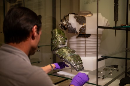 Dr Fraser Hunter installs the Roman arm guard in the Early People gallery at the National Museum of Scoltand. Image copyright Duncan McGlynn (11)