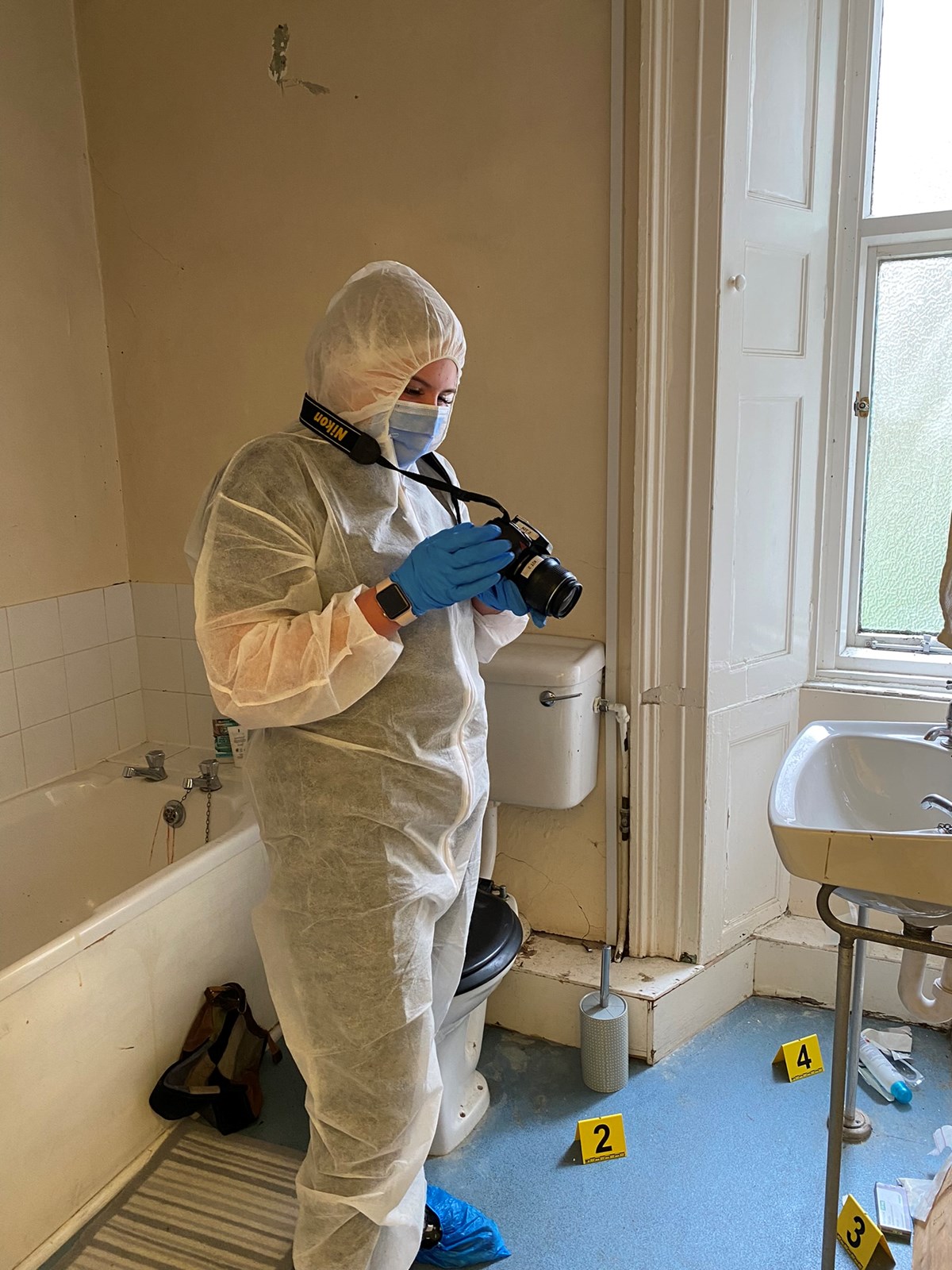 Crime scene investigator photographs a crime scene with evidence markers