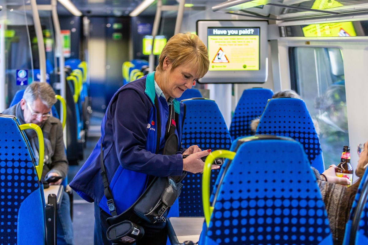 Image shows conductor performing on-board ticket checks