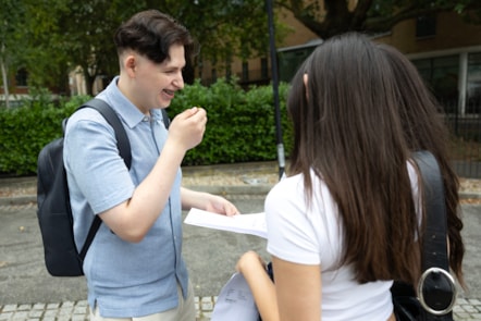 Capital City College Group student Dragos celebrates his results with two friends outside the Angel campus