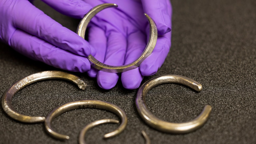 Assistant Curator Craig Angus with silver arm rings from the Burray Hoard. Photo © Duncan McGlynn (2)