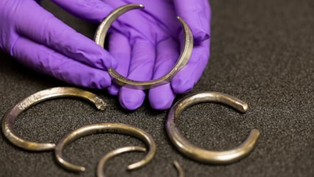 Assistant Curator Craig Angus with silver arm rings from the Burray Hoard. Photo © Duncan McGlynn (2)