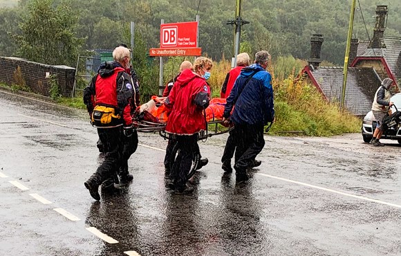 Buxton Mountain Rescue team carrying Denis across a road for medical checks