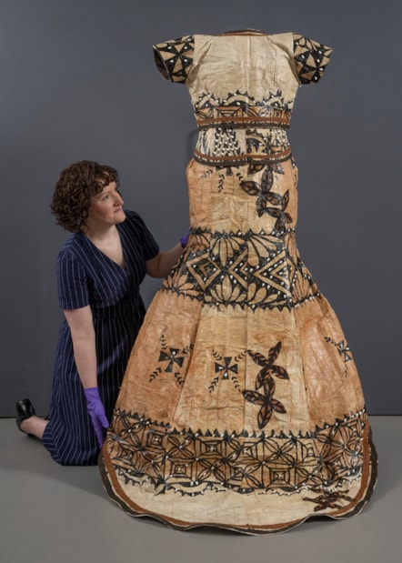 Curator Ali Clark prepares the barkcloth wedding dress for display. Photo © Neil Hanna (1)