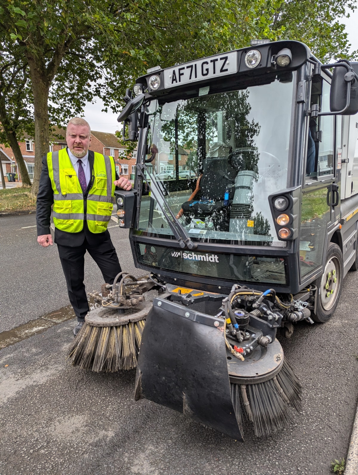 Cllr Damian Corfield with the roadsweeper carrying the new weed ripper arm