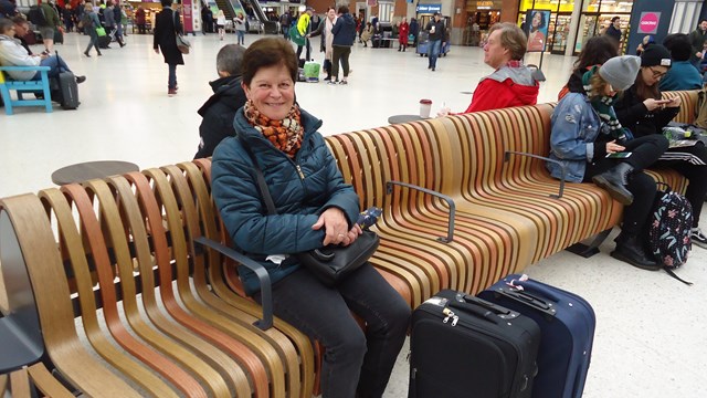 Satisfied rail passenger sitting on new seating at Victoria station
