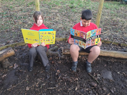 Pupils Abbie and Kaiyan reading in the forest school at Howick Church of England Primary School.jpg