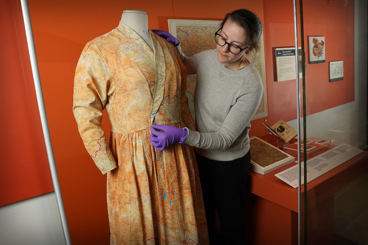 Assistant Textile Conservator, Stella Gardner adjusting a silk dress made from escape and evade maps used during the Second World War, on loan from Worthing Museum and Art Gallery. Image © Stewart Attwood