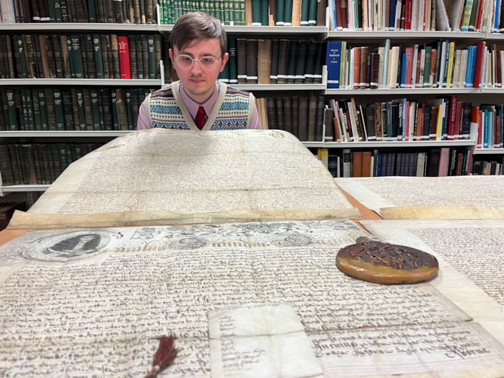 The Leeds Charter: Alex Pearson, archives assistant with West Yorkshire Archive Service with the copy of the Leeds Charter and  a second ornate charter, granted decades later in 1661 by Charles II.
The granting of the prestigious charter changed the course of the city’s history, laying the foundations of modern-day Leeds by incorporating it as a “free borough” and a “body corporate and politic.”