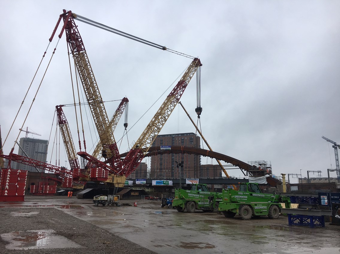 Two cranes lifting the Ordsall Chord network arch into place