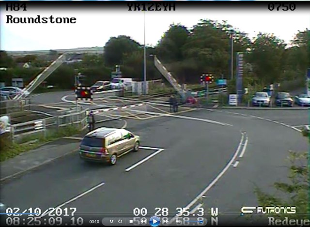 Roundstone level crossing CCTV still: Roundstone level crossing CCTV still - the cyclist is about to duck under the falling barrier