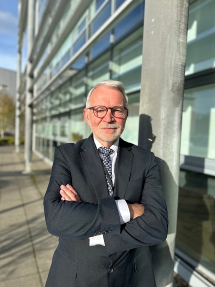 Stuart Corbridge, chief executive, standing outside NEAS headquarters with his arms crossed.