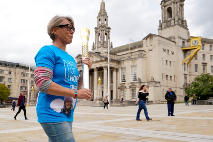 Baton of Hope - Leeds tour 1: Baton bearer Caroline Litman carries the baton across Millennium Square as the Baton of Hope tour comes to Leeds on World Suicide Prevention Day.