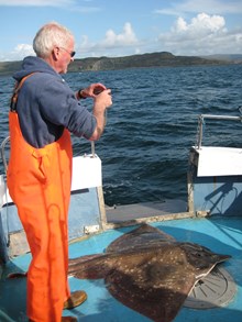 Skipper Ronnie Campbell photographing skate © Jane Dodd/SNH